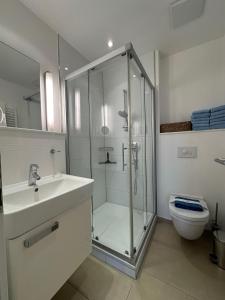 een badkamer met een douche, een wastafel en een toilet bij Georg6 GEORG6 - Fewo 4 in Norderney