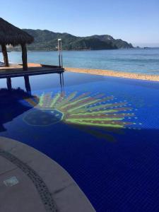 una piscina junto a una playa con agua en Tai Condo 2, en Barra de Navidad