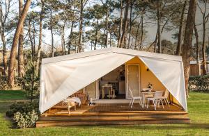 Tenda con tavolo e sedie su una terrazza di Camping Villaggio Internazionale a San Menaio