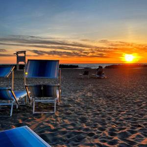 Un grupo de sillas en una playa al atardecer en Bed&Beach, en Fiumicino