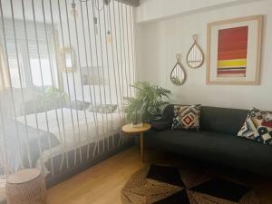 Apartamento Loft centro Santiago في سانتياغو دي كومبوستيلا: غرفة معيشة مع أريكة خضراء وطاولة