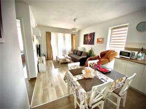 a kitchen and living room with a table and chairs at Relaxing Coresi Studio in Braşov