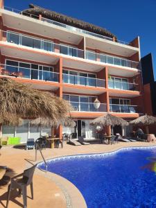 a hotel with a swimming pool in front of a building at Tai Condo 3 in Barra de Navidad