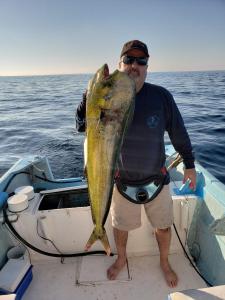 a man holding a large fish in a boat at Tai Condo 3 in Barra de Navidad