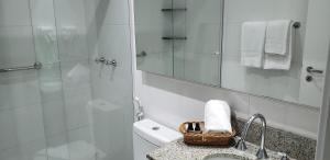 een badkamer met een wastafel en een douche met een spiegel bij 616A life (Batistela) · Studio Centro|Batel, moderno e bem equipado! in Curitiba