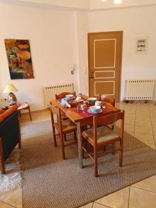 Delphion House في أراخوفا: غرفة معيشة مع طاولة وكراسي خشبية