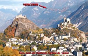 un castillo en la cima de una montaña con una ciudad en La Montagnette, VERCORIN, en Vercorin