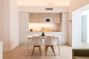 een keuken met een tafel en stoelen in een kamer bij Villalobos Suites by Luxury Suites Cadíz in Cádiz