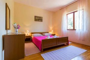 1 dormitorio con 1 cama con colcha rosa en Peaceful Oasis, en Banići