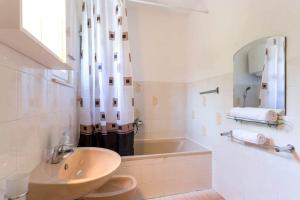 a white bathroom with a sink and a tub at Peaceful Oasis in Banići