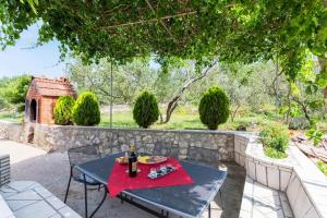 a table and chairs on a patio with a stone wall at Peaceful Oasis in Banići