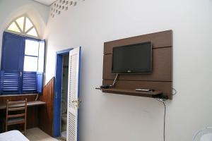 a living room with a tv on a wall at Hotel Providencia in Mariana