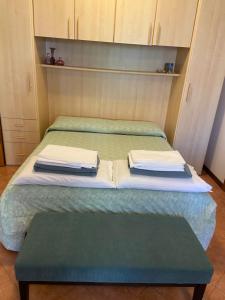 uma cama com duas almofadas em cima em Caorle & Caorle em Caorle