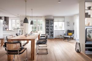 a kitchen and dining room with a wooden table and chairs at Hus Andersen in Nieblum