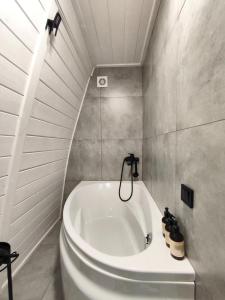 a white bath tub in a bathroom with a ceiling at Black Dora in Yaremche