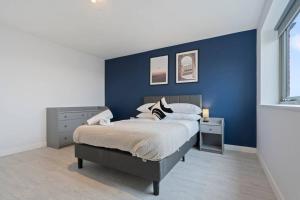 a bedroom with a blue accent wall and a bed at Exquisite 7 Bedroom 5.5 Bathroom House - Over 1900 sqft - Close to City Centre with Free Parking, Fast W-Fi and SmartTVs by Yoko Property in Northampton