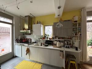 eine Küche mit weißen Schränken und einem großen Fenster in der Unterkunft Belle maison de ville dans Lyon in Lyon