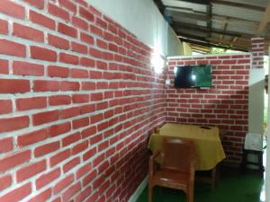 a brick wall with a table and a tv on it at Sisila Guest House in Polonnaruwa