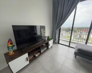 a living room with a flat screen tv and a couch at Happy House in Sandakan