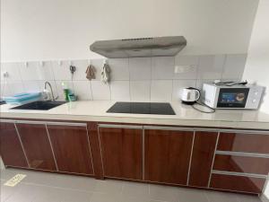 サンダカンにあるHappy Houseのシンクと電子レンジ付きのキッチン +5枚の写真