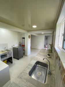 eine Küche mit einer Spüle aus Edelstahl in einem Zimmer in der Unterkunft Villa Jair Hotel in Filandia