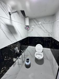 a bathroom with a white toilet and a sink at HOTEL THE PACIFIC in Ahmedabad
