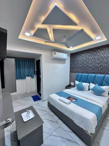 a bedroom with a large bed with blue pillows at HOTEL THE PACIFIC in Ahmedabad