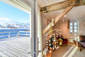 a living room with a view of the ocean at Kongsfjord Arctic Lodge in Kongsfjord