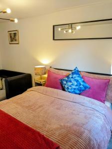 a bedroom with a bed with colorful pillows at Small 1-Bed Apartment in London in Croydon