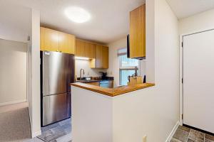 a kitchen with wooden cabinets and a stainless steel refrigerator at Butternut Hill D4 in Waitsfield