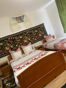 a bedroom with two beds and a headboard at Pensiunea Ioana Mariana in Botiza