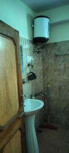 łazienka z umywalką i lampką na ścianie w obiekcie Hotel Gopi Dham Ashram Haridwar Near Vrindavan w mieście Haridwar