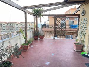 eine Terrasse mit Topfpflanzen auf dem Balkon in der Unterkunft Le Palme in Lido di Ostia