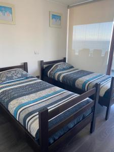 due letti uno accanto all'altro in una stanza di Departamentos Mednav Montemar & Spa a Concón