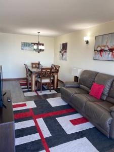 un soggiorno con un divano e un tavolo di Departamentos Mednav Montemar & Spa a Concón