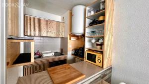 uma pequena cozinha com uma mesa e um micro-ondas em La Piste em Saint-Lary-Soulan