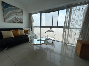un soggiorno con divano e tavolo in vetro di Ecusuites Riverfront One Vista al Río Jacuzzi Hidro a Guayaquil