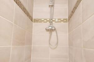 eine Dusche mit Duschkopf im Bad in der Unterkunft Discount Gite confort Sortie Besançon Texas T3 in Chevigney-sur-lʼOgnon
