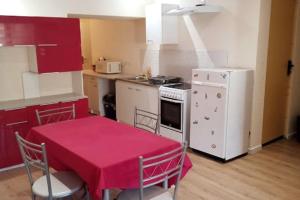 uma cozinha com uma mesa com uma toalha de mesa vermelha em Discount Gite confort Sortie Besançon Texas T3 em Chevigney-sur-lʼOgnon