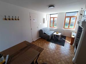 ein Wohnzimmer mit einem blauen Stuhl und einem Tisch in der Unterkunft Au Nid Douillet in Saint-Jans-Cappel