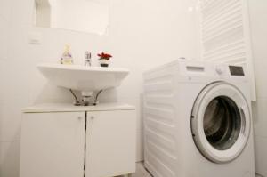 a bathroom with a washing machine and a sink at Family Apartment MZ27 in Vienna