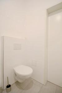 a bathroom with a white toilet in a white wall at Family Apartment MZ27 in Vienna