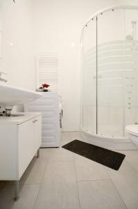 a white bathroom with a shower and a sink at Family Apartment MZ27 in Vienna