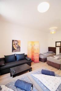 a living room with a black couch and some tables at Family Apartment MZ27 in Vienna