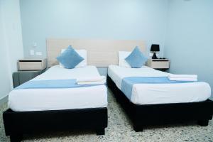 dwa łóżka siedzące obok siebie w pokoju w obiekcie Casa Franco Hotel w mieście Cartagena de Indias