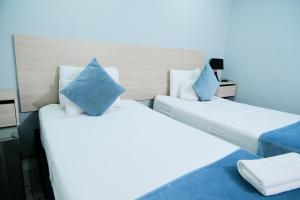 two beds in a hotel room with blue pillows at Casa Franco Hotel in Cartagena de Indias