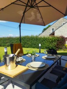 una mesa con platos de comida y una sombrilla en Gîte A Brouca, en Gouvy