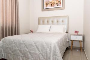 um quarto com uma cama com um edredão branco em Las Palmeras Hospedaje & Restaurante em Nuevo Imperial