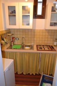 a kitchen counter with a sink and a stove at Casa Colorata in Palermo