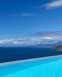 a swimming pool with a view of the ocean at BASSA MAINA Villas & Suites in Areopoli